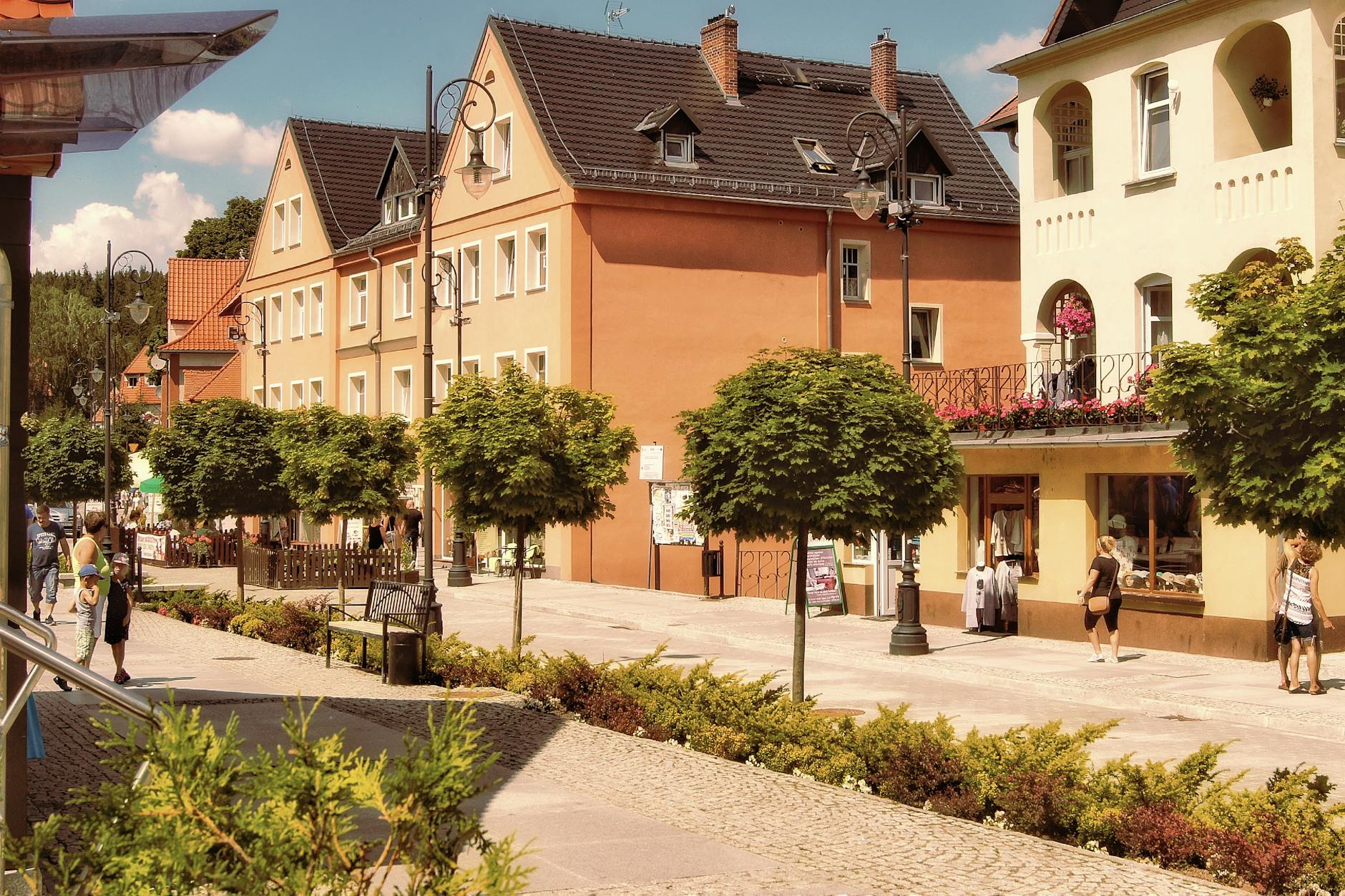 Malowniczy widok na jezioro w Augustowie z plażą i drzewami w tle, symbolizujący początek lata.
